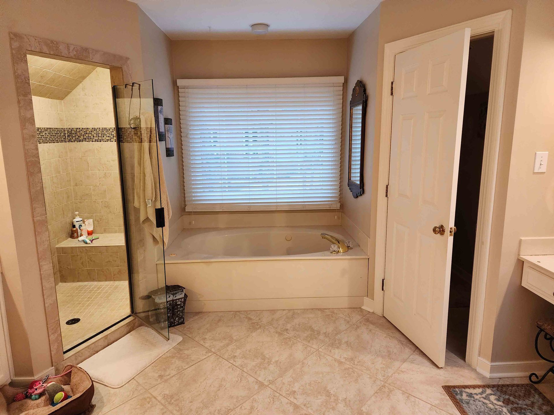 A bathroom with a tub , shower , sink and mirror.