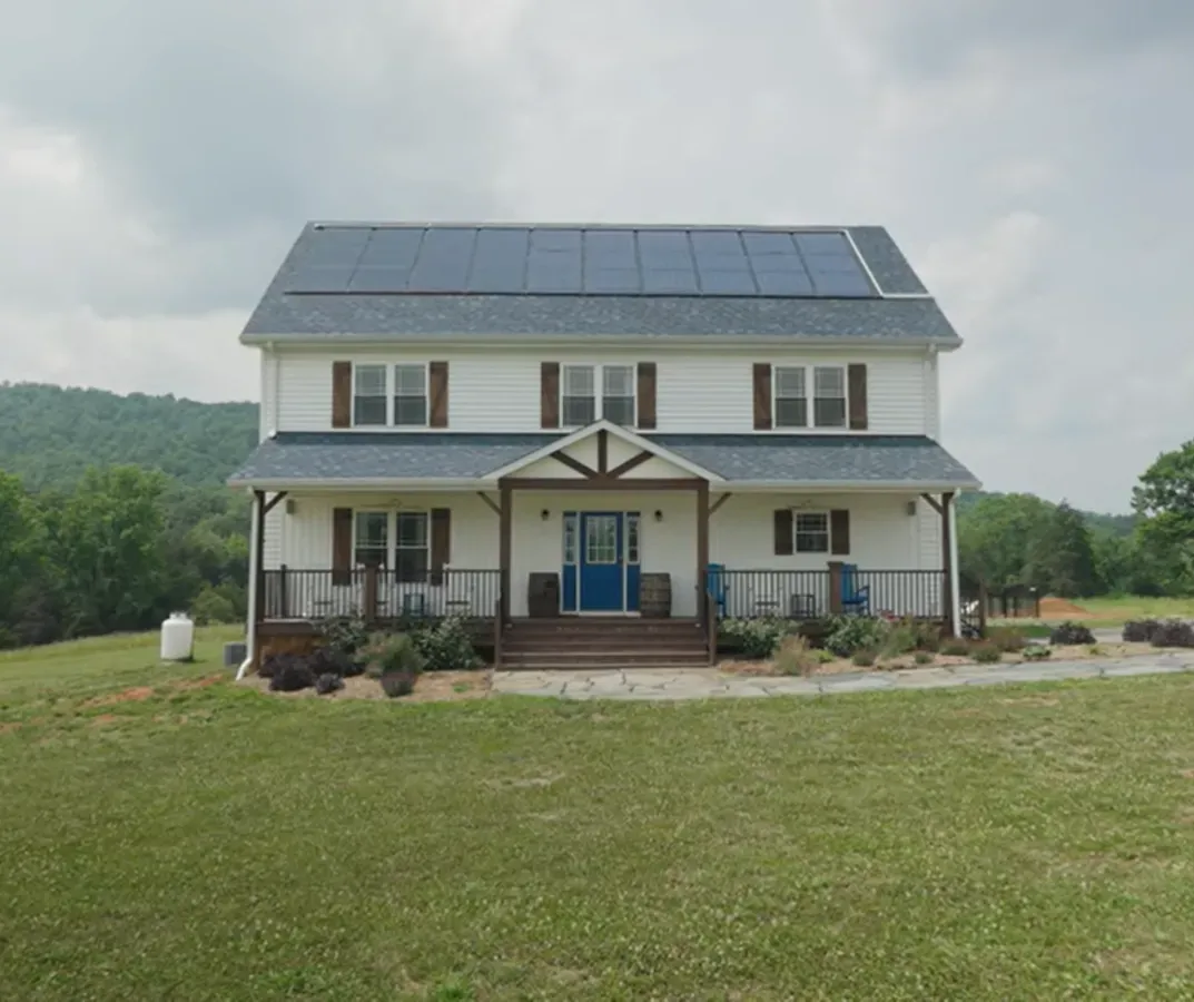 A large white house with solar panels on the roof