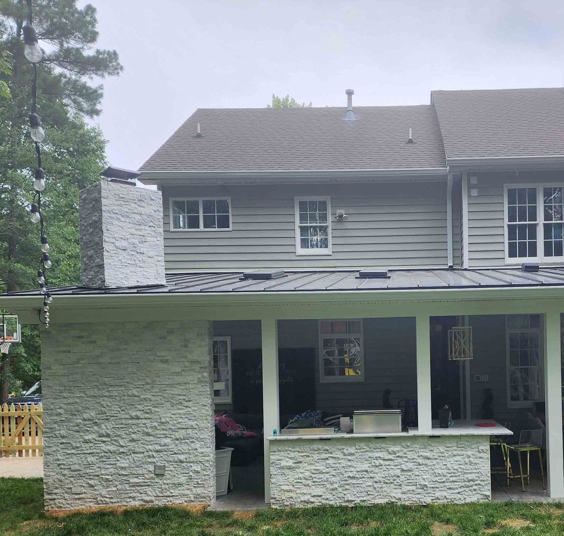 A kitchen with white cabinets , a sink , a microwave , and a window.