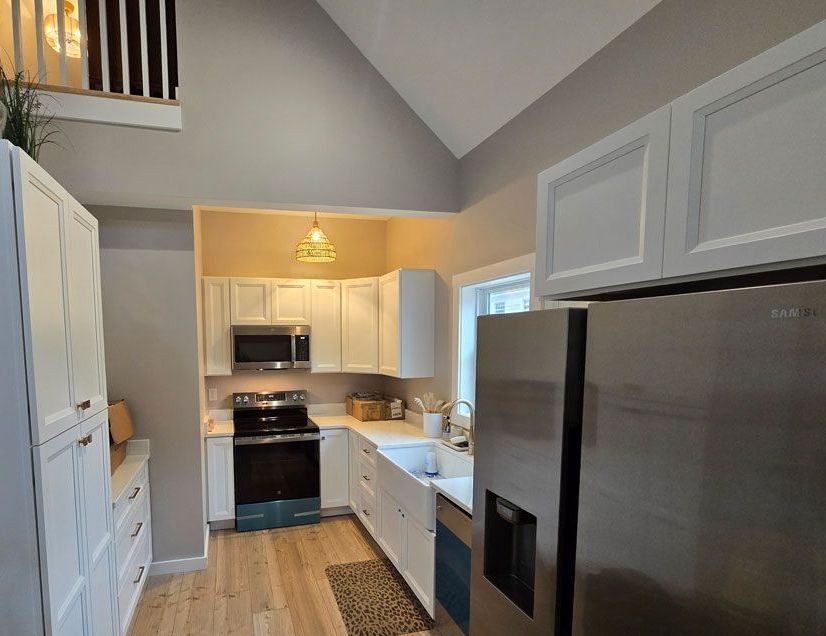 A kitchen with stainless steel appliances and white cabinets