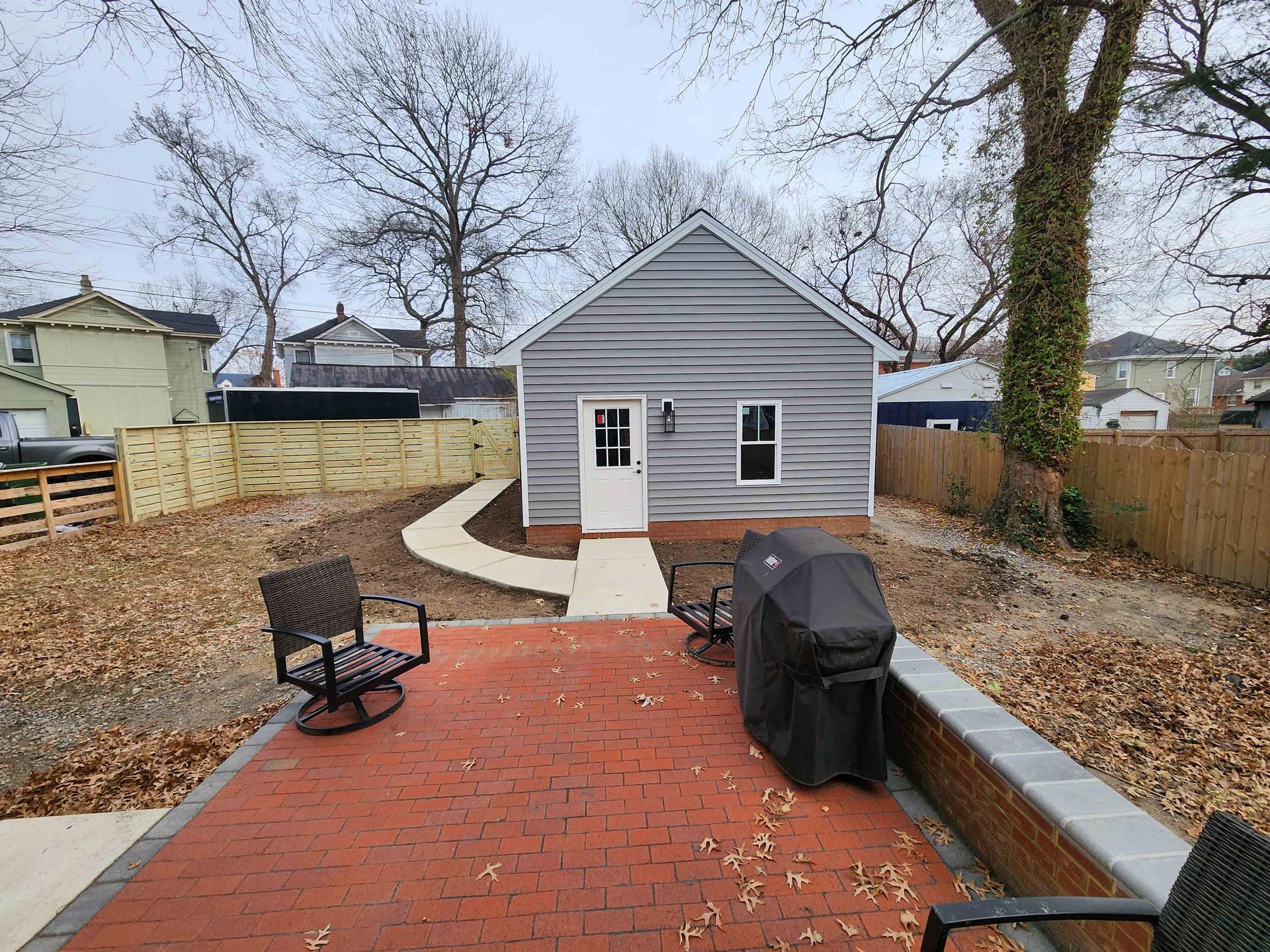 A small house with a brick walkway leading to it.