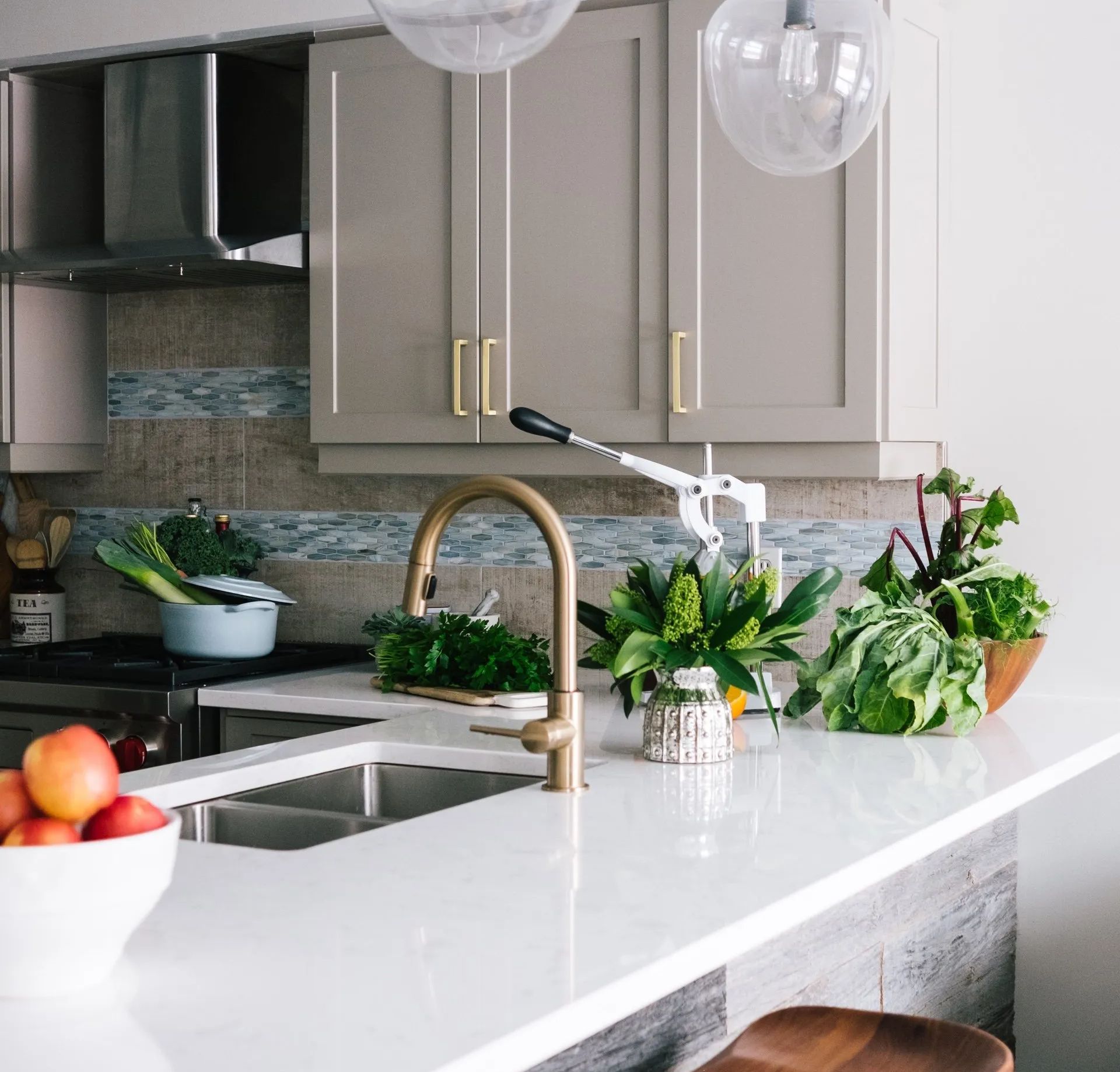 A kitchen with a sink and a bowl of fruit on the counter