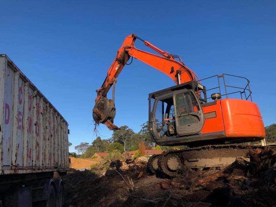 An orange crane undertaking demolition work.