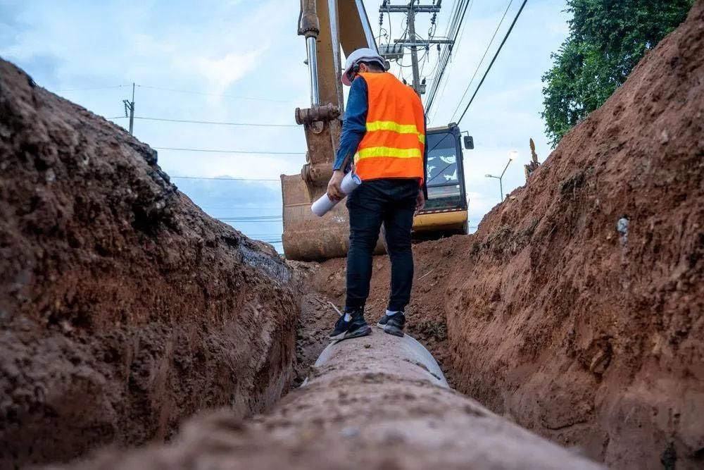 A Man Is Standing in A Trench Next to A Pipe — Central Coast Complete Demolition & Tree Service in Buff Point, NSW