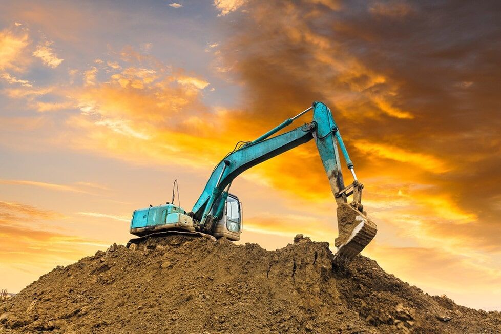 A Blue Excavator Is Sitting On Top Of A Pile Of Dirt — Kset Engineering in Thornton, NSW