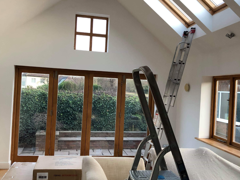 Picture of a living room interior painted in white with timber patio doors newly varnished and painted by painters and decorators Birmingham.