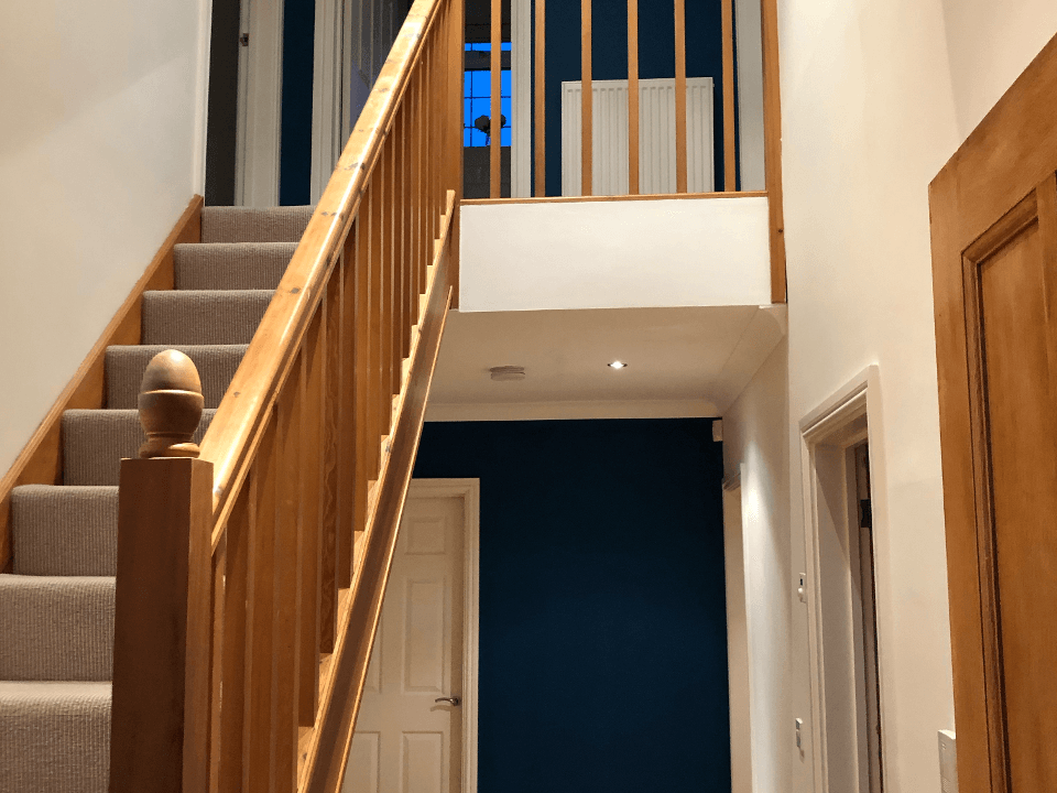 Picture of an internal hallway and wooden staircase. The walls have been painted in magnolia and the staircase has been varnished by painters and decorators Birmingham