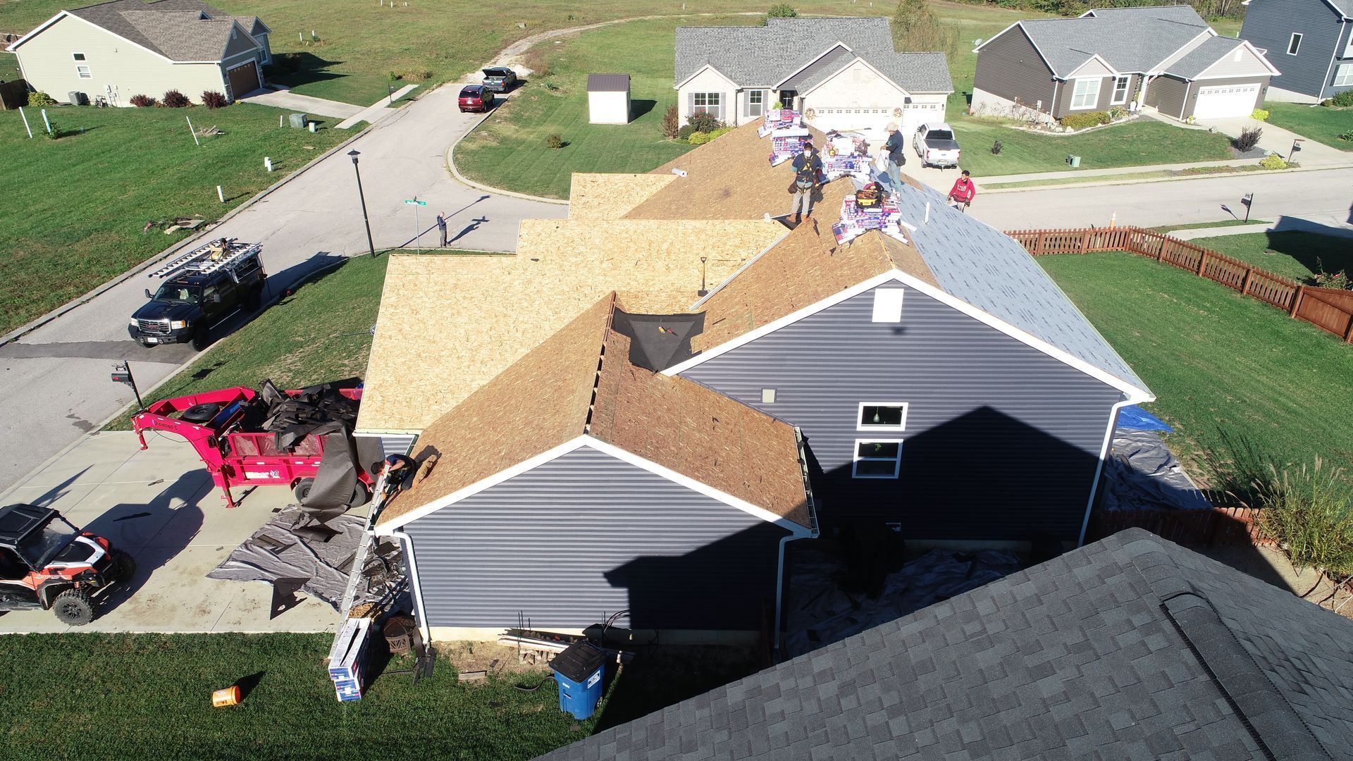 A group of people are working on the roof of a house.