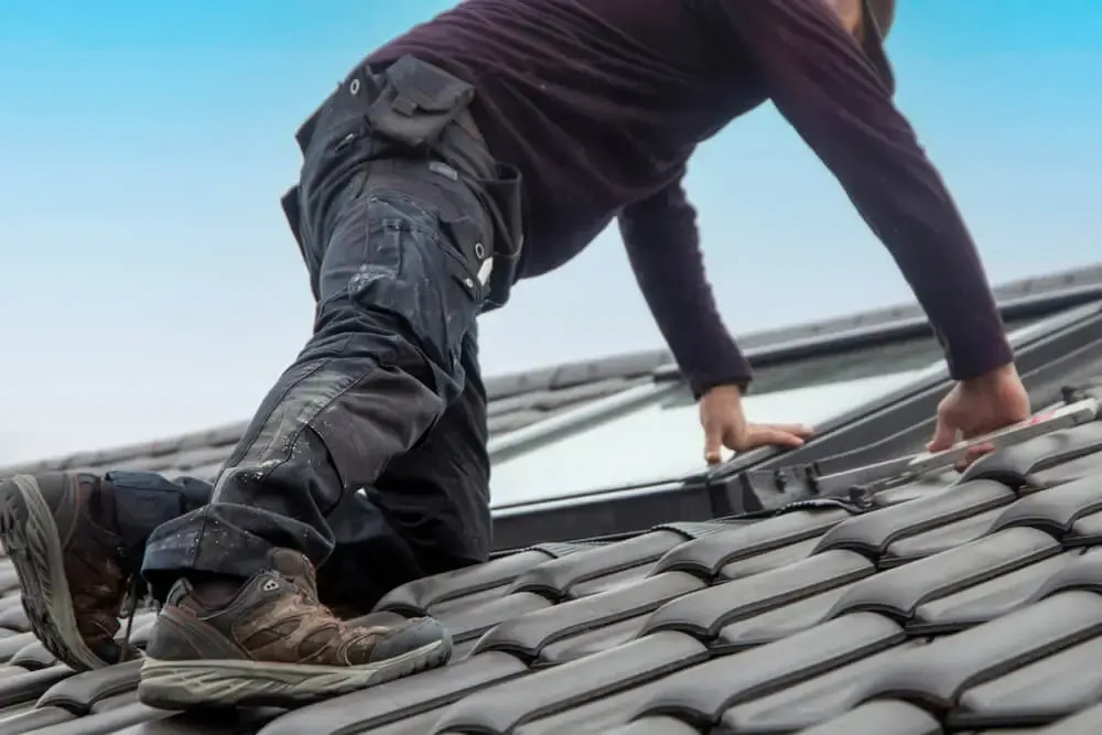 Roofer installing a new roof skylight