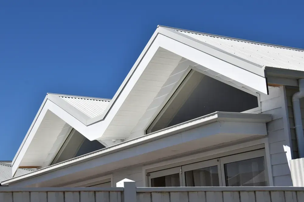 Modern architectural style metal joined twin gable and M shape valley roof line with large rafter wi