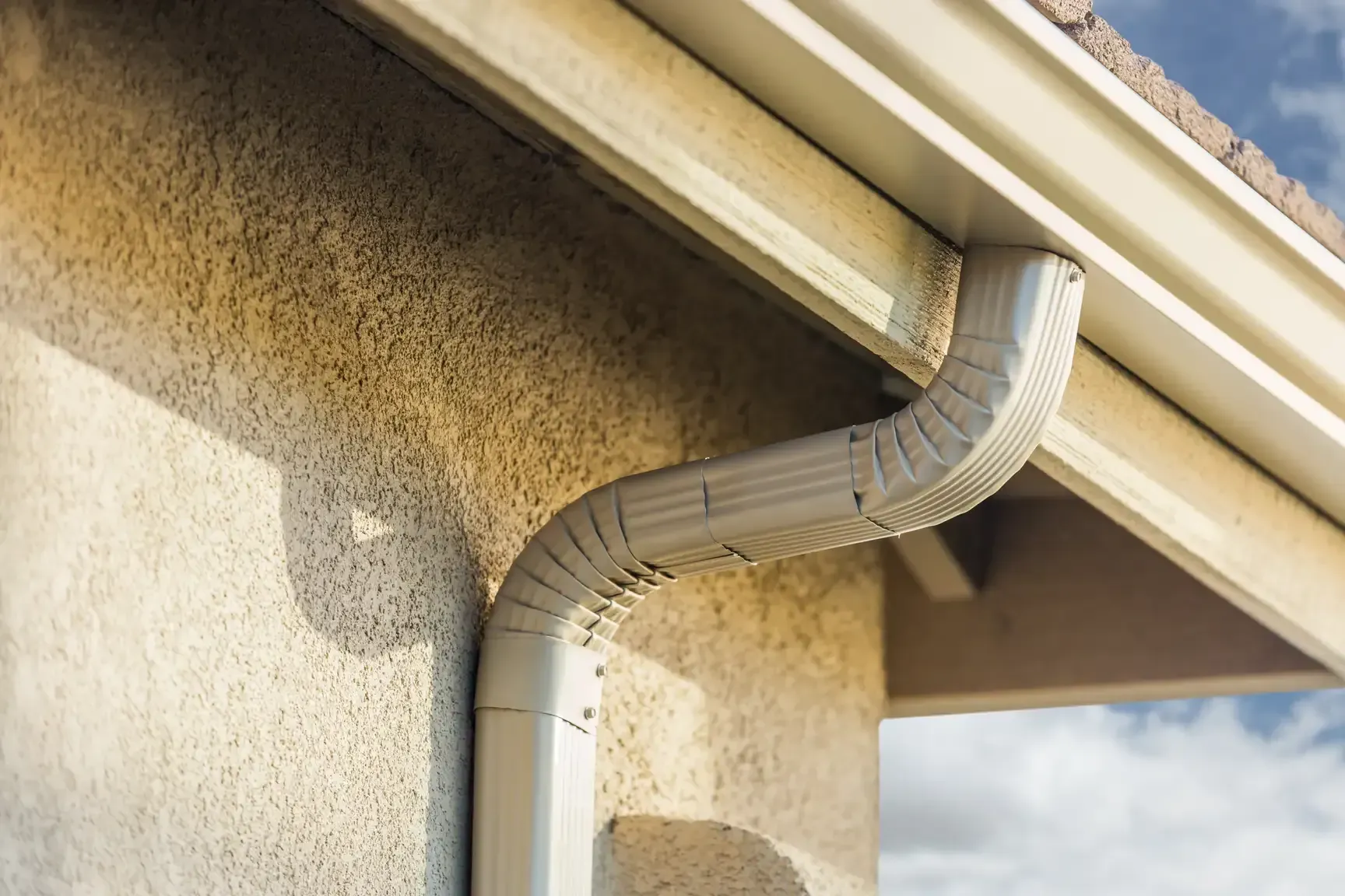 Sectional gutters with visible seams on house exterior showing aluminum gutter joints