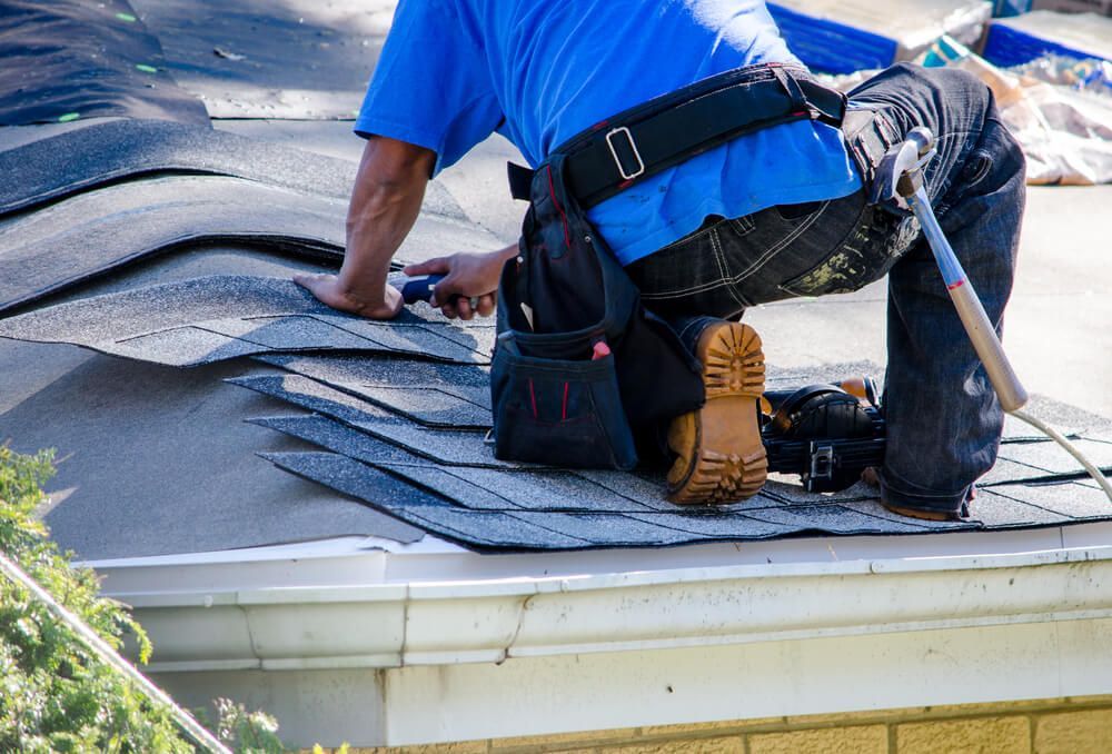 Roofing contractor repairing the roof of a home