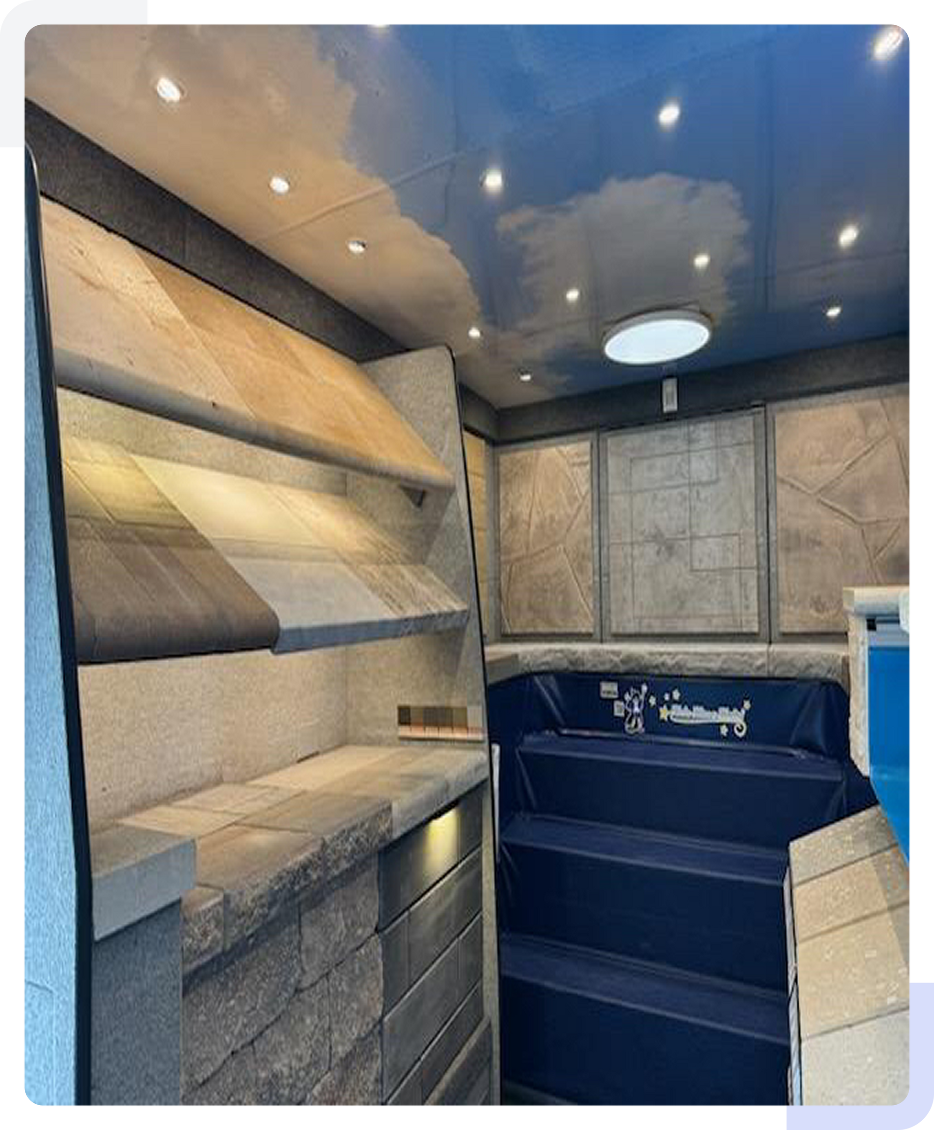 Rectangular pool with turquoise water, surrounded by wooden decking and three striped lounge chairs.