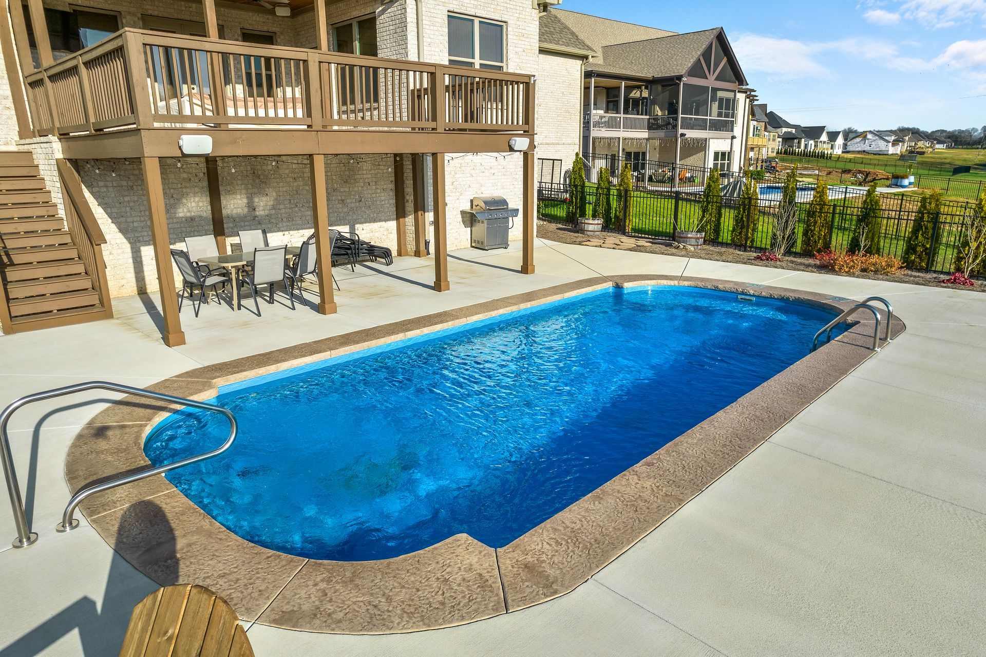 Brick house with a gray roof and wood accents; front yard with bushes.