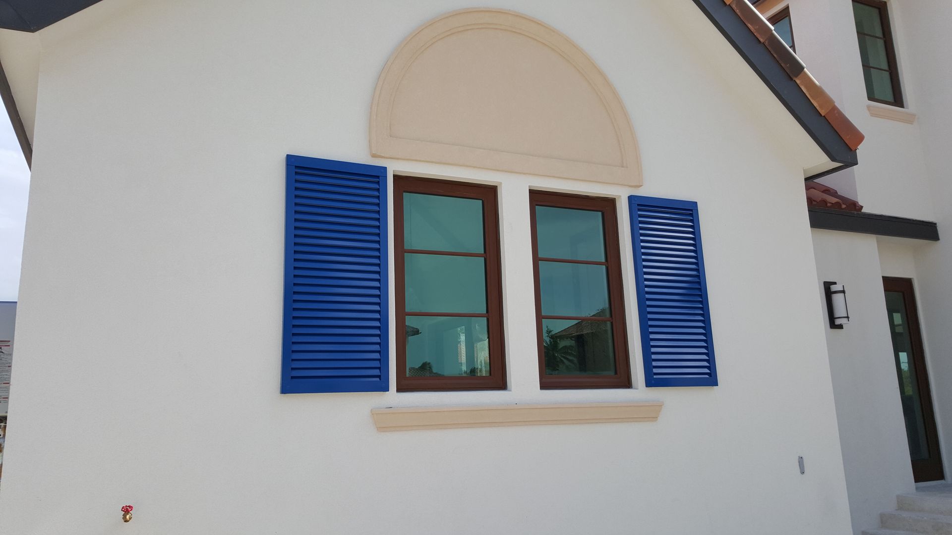 A white house with blue shutters on the windows