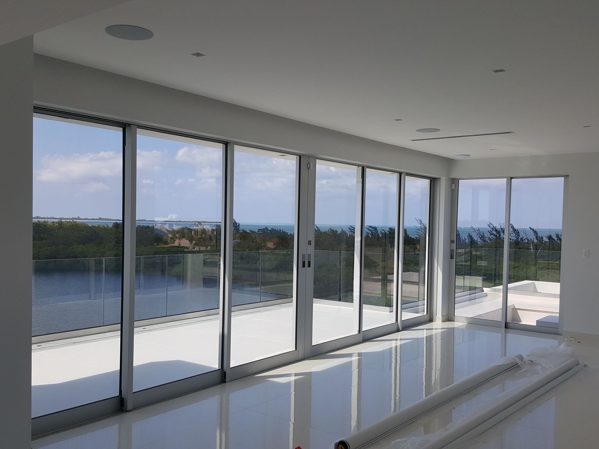 A room with a lot of windows and a view of a lake