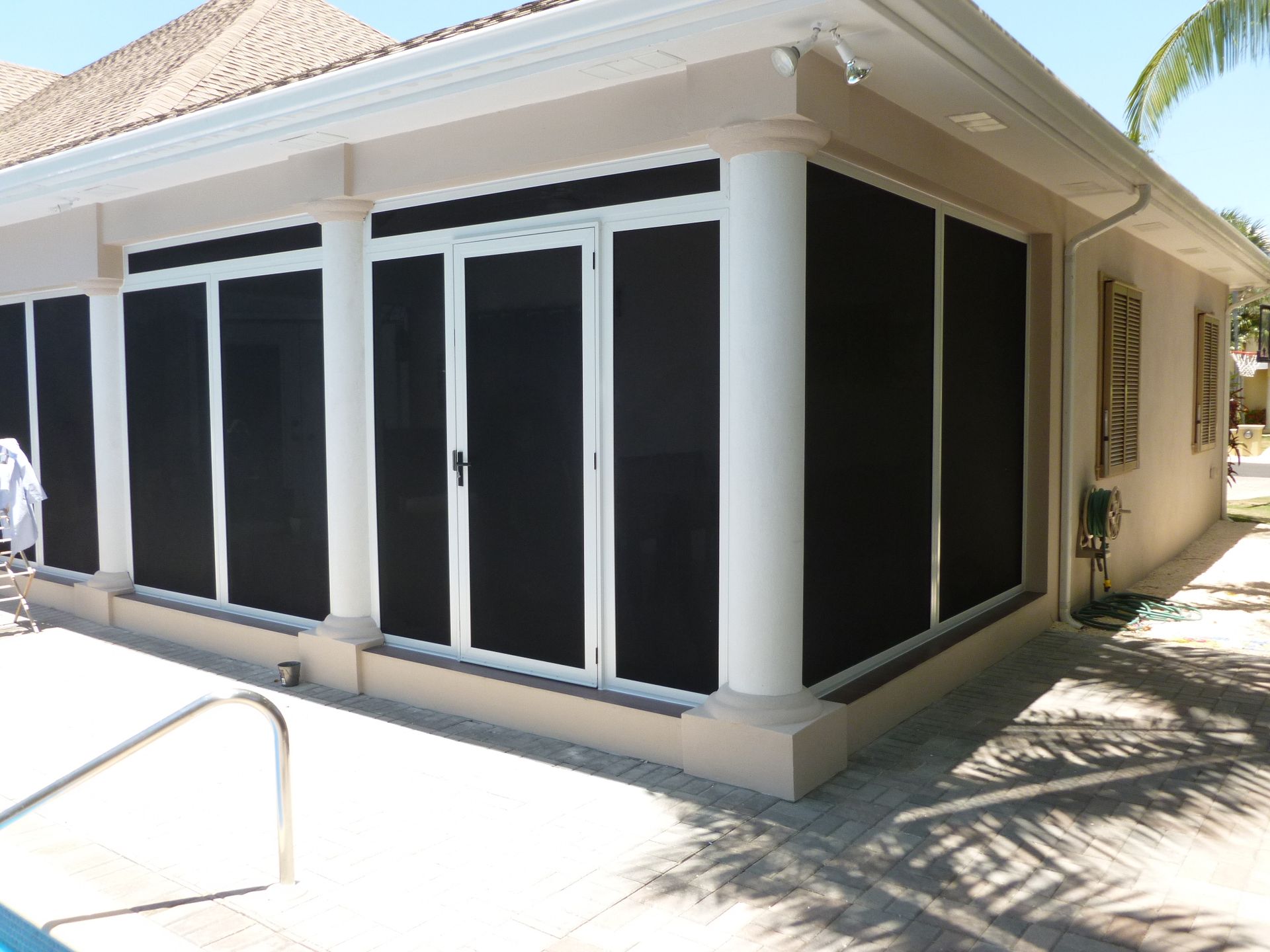 A white house with black screens on the windows and doors.