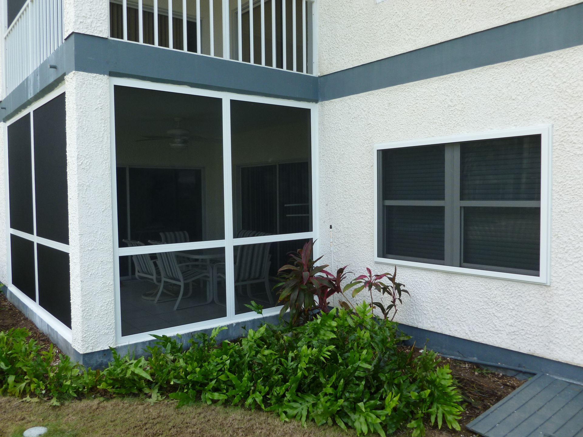 A screened in porch on the side of a building