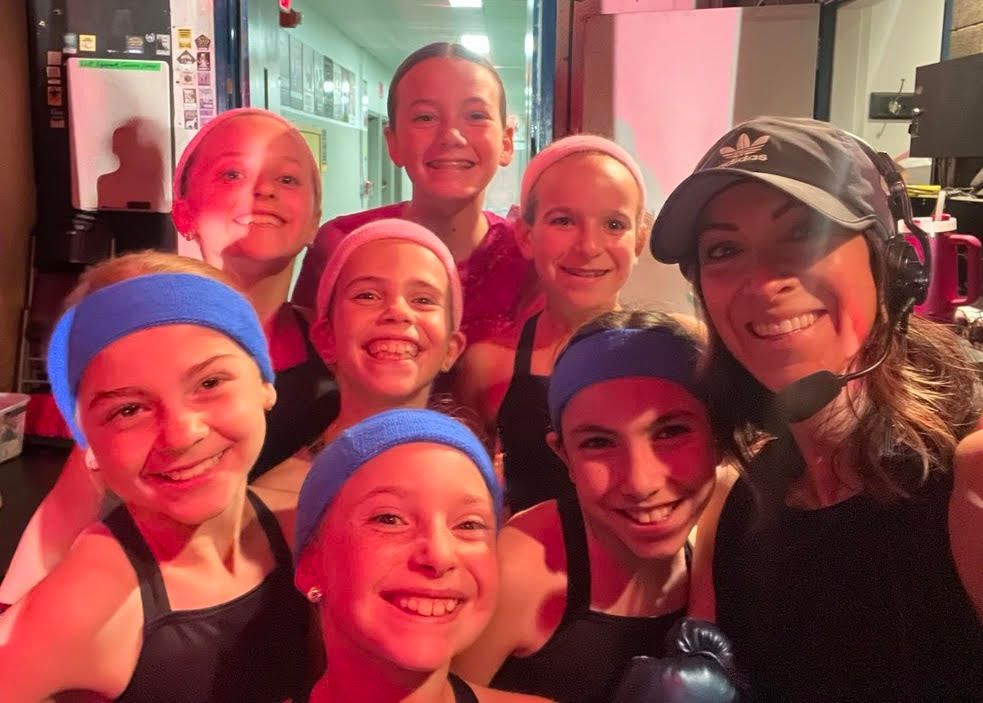 A group of young girls wearing headbands are posing for a picture