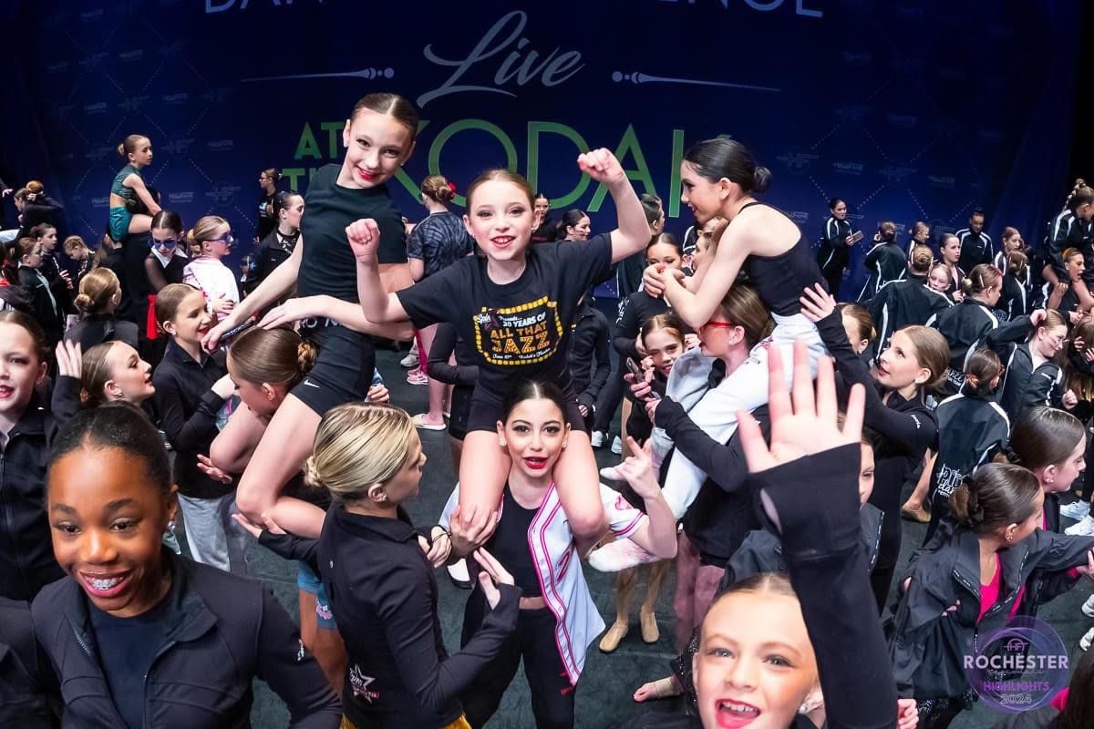 A group of young girls are posing for a picture at a dance competition.