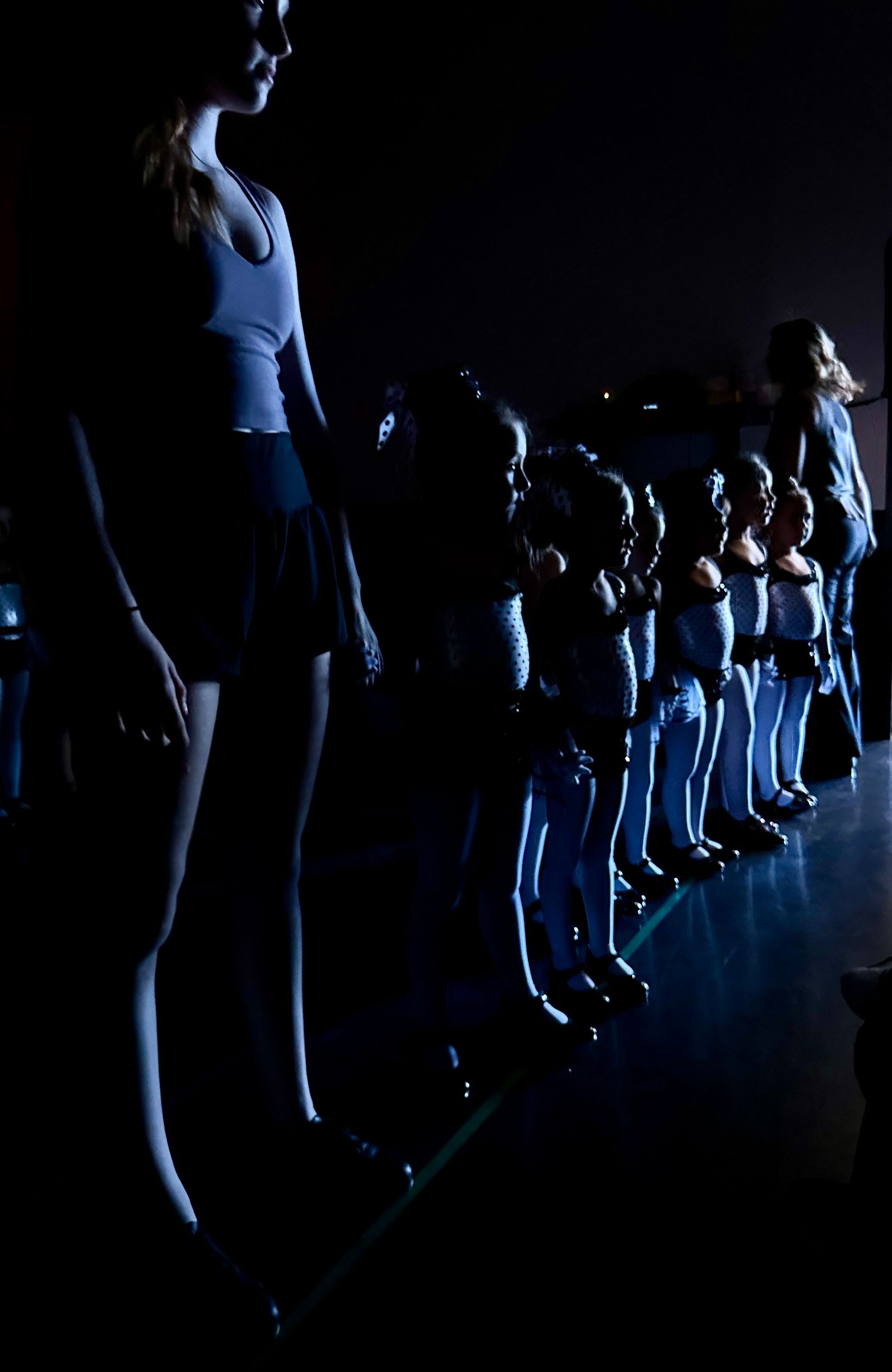 A group of people are standing in a dark room.