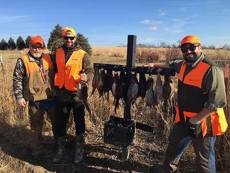Two women looking at notepad, smiling. One points, the other holds the pad and pen, discussing at a table.