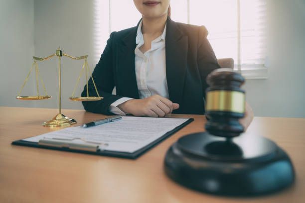 Lawyer at desk with gavel, scales of justice, and documents.