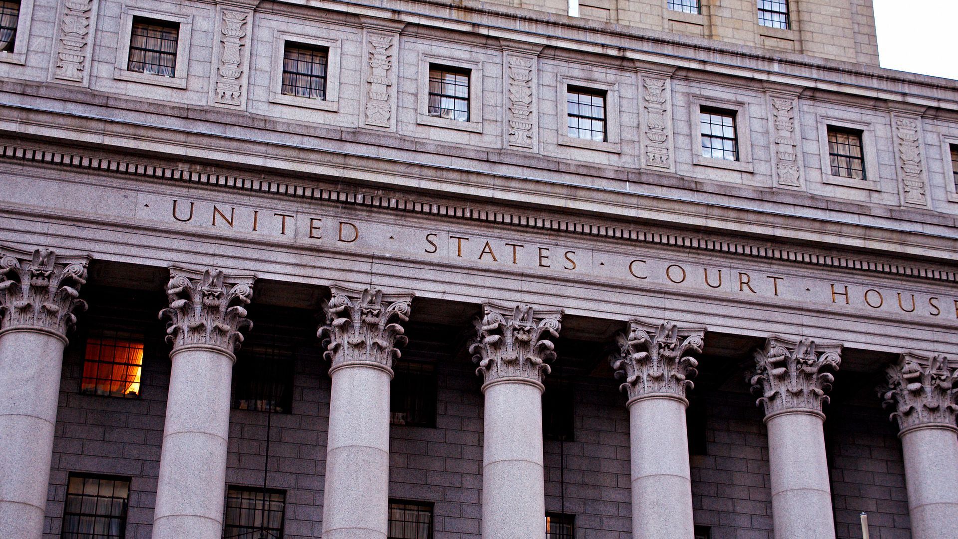 Exterior of the United States Courthouse building, white stone facade with columns and inscription.