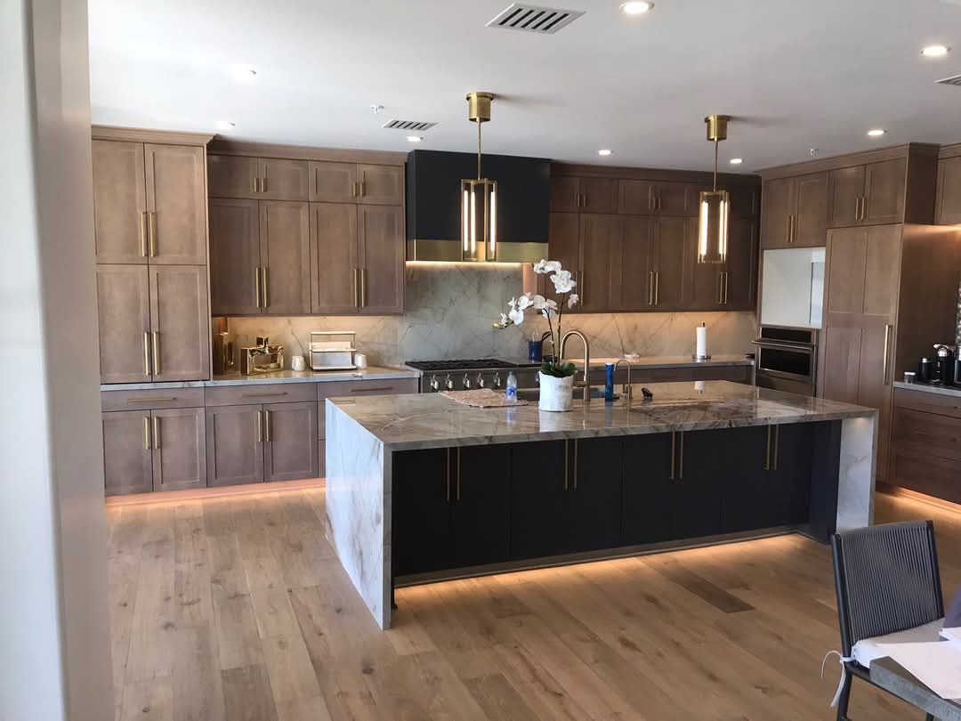 A kitchen with wooden cabinets and a large island