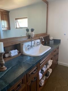 A bathroom with a sink and a large mirror.