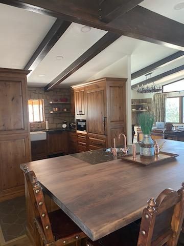 A kitchen with a large wooden table and chairs.