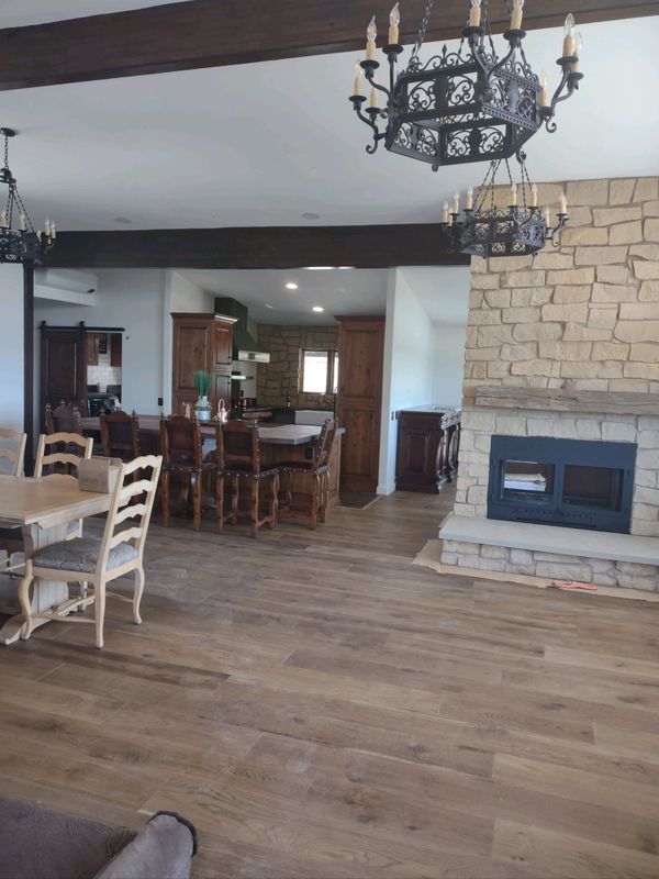 A living room with a fireplace and a table and chairs
