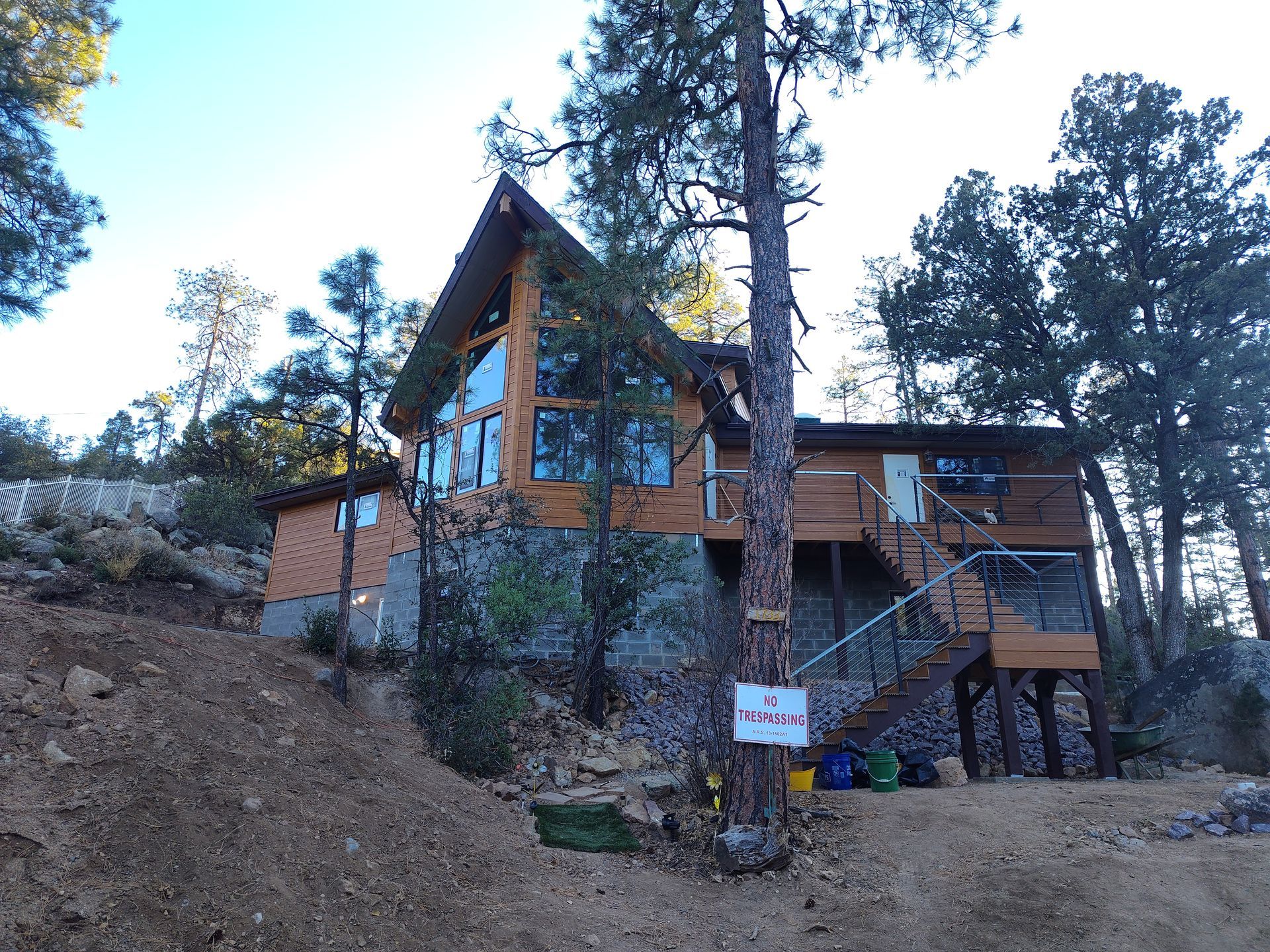 A large house is surrounded by trees and a sign that says no parking