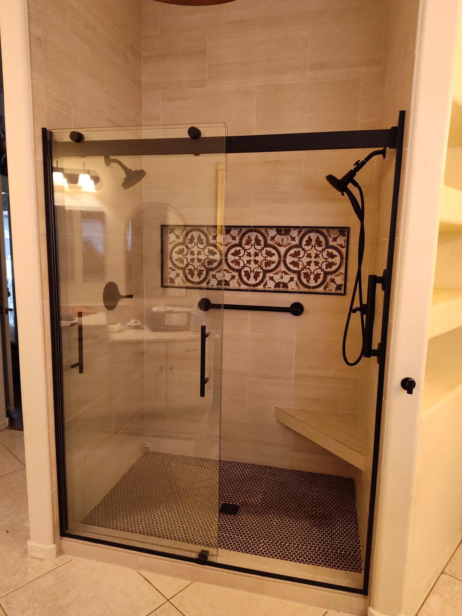 A bathroom with a sliding glass shower door
