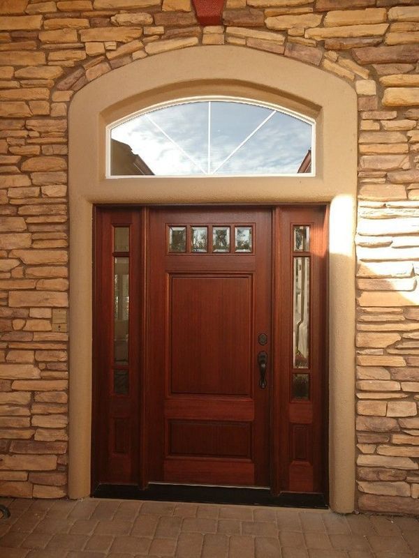 A wooden door with a stone wall behind it