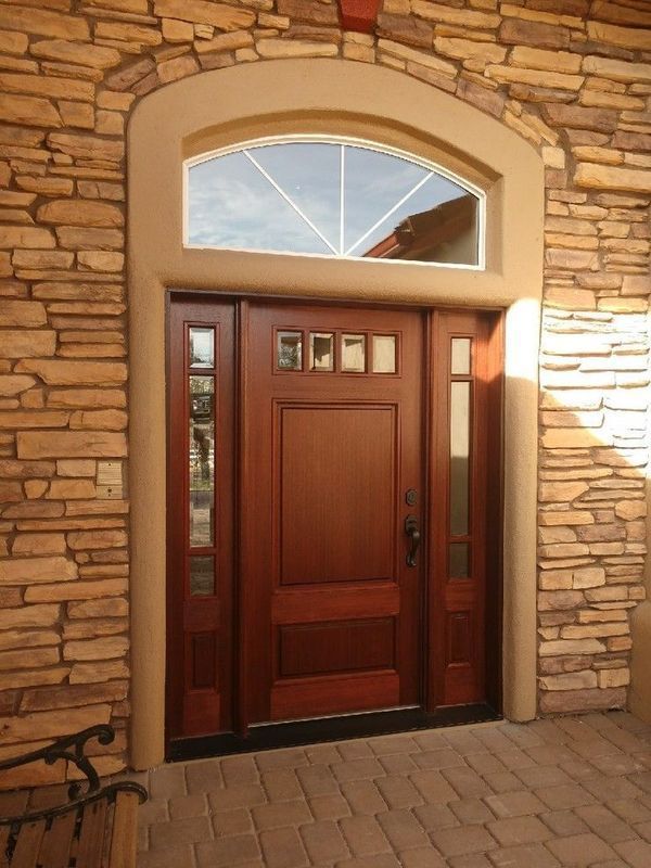 A wooden door with a stone wall behind it