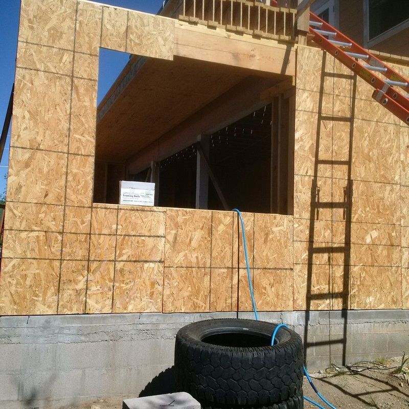 A large tire is sitting in front of a building under construction