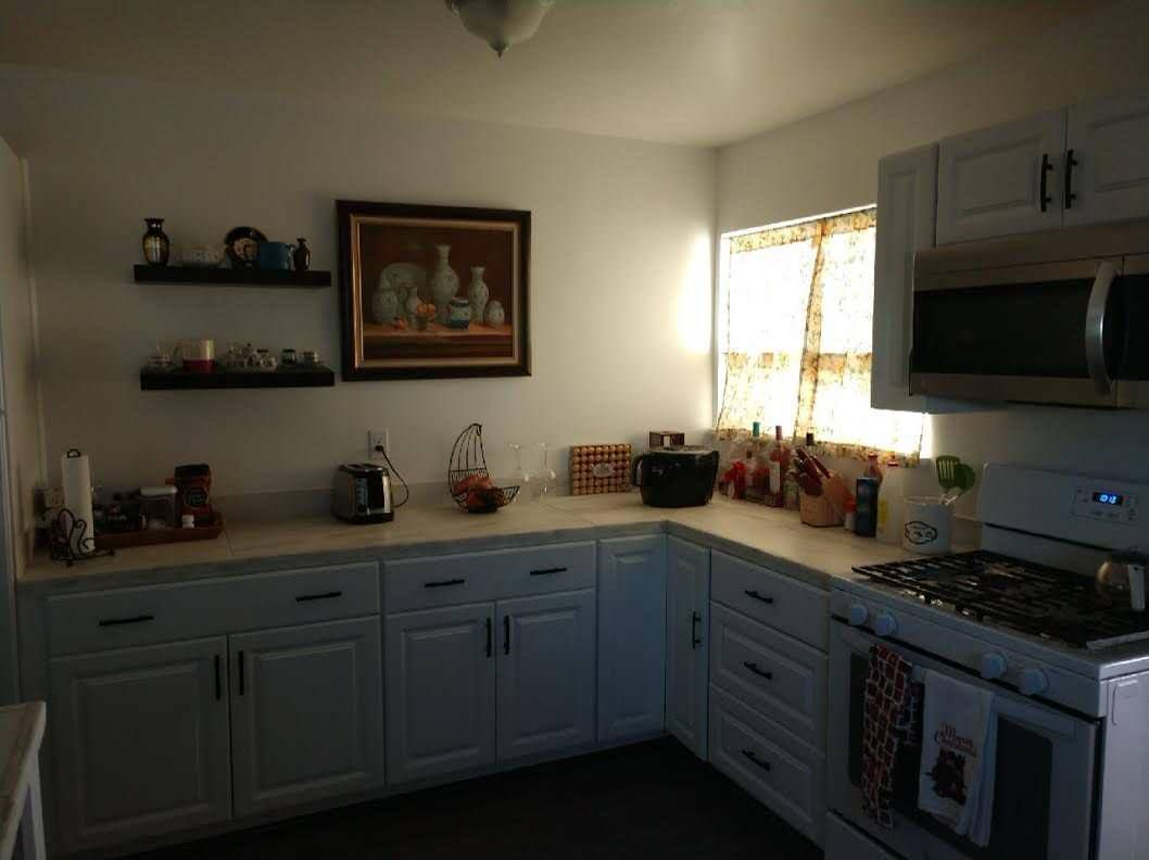A kitchen with white cabinets and stainless steel appliances