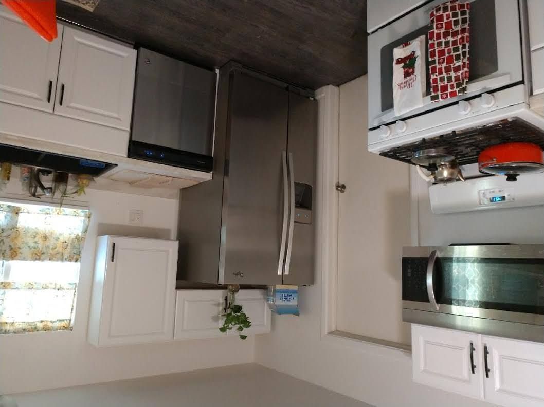 A kitchen with stainless steel appliances and white cabinets