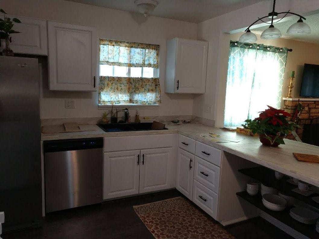 A kitchen with white cabinets and stainless steel appliances