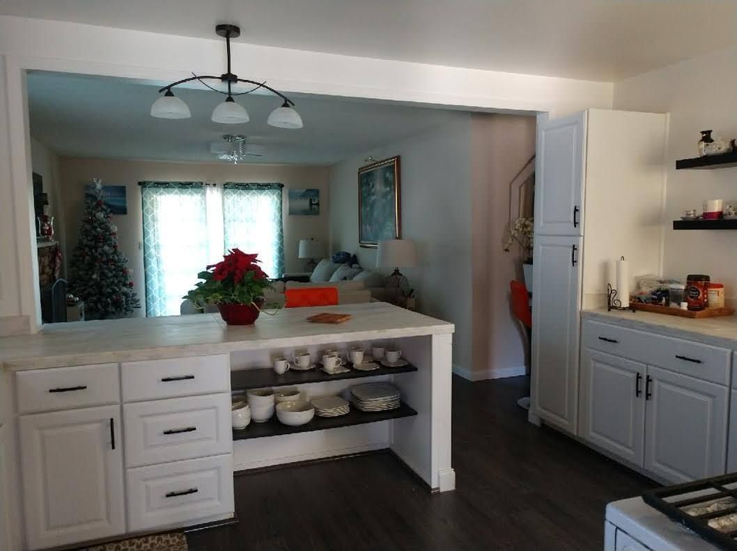 A kitchen with white cabinets and a large island in the middle.