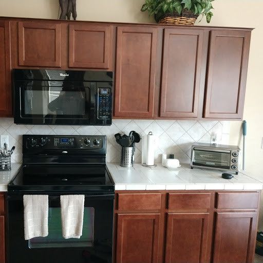 A kitchen with wooden cabinets and a black stove top oven