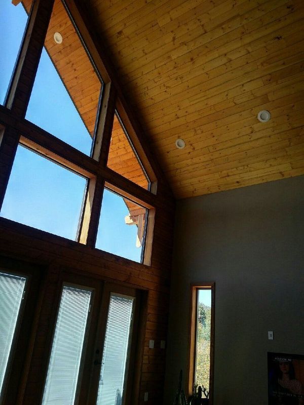 A room with a lot of windows and a wooden ceiling