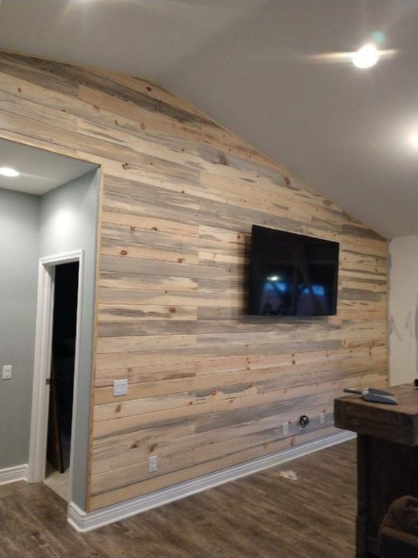 A living room with wood paneling and a flat screen tv on the wall.
