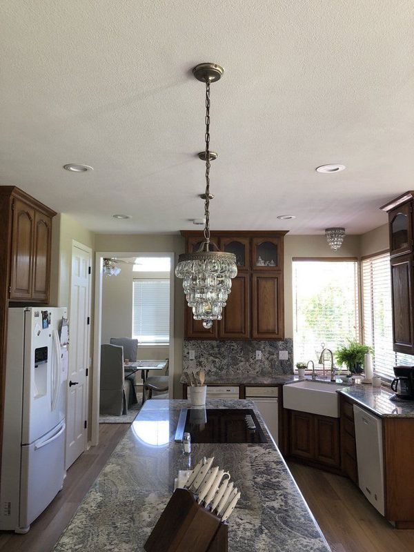 A kitchen with a large island and a chandelier hanging from the ceiling