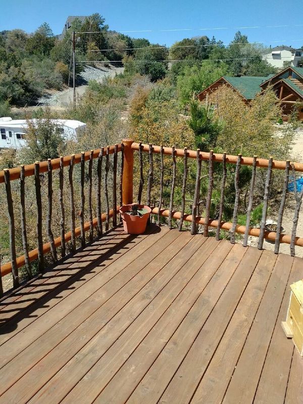 A wooden deck with a wooden railing and a potted plant on it