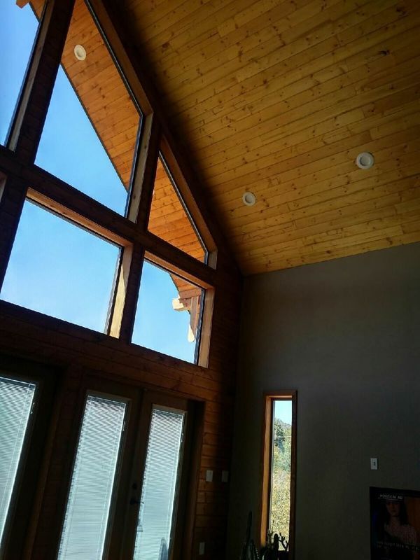 A room with a lot of windows and a wooden ceiling