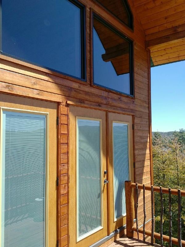 A wooden house with a balcony and sliding glass doors
