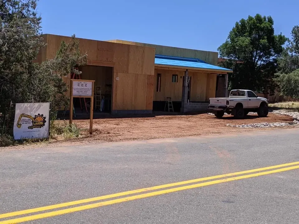 Building under construction; wood frame with truck parked out front.