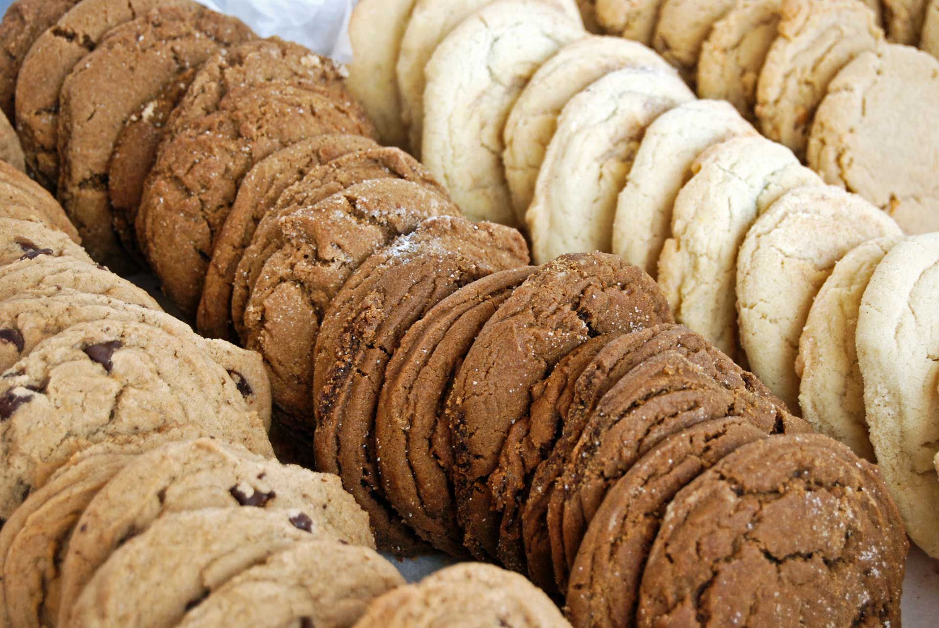 Assorted cookies, arranged in rows: chocolate chip, dark brown, and light brown.